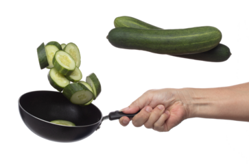Cucumber fly fall in pan, green fresh vegetable cucumber cut chop slice. Organic fresh vegetable with eaten leaf of long cucumber, close up texture. White background isolated freeze motion high speed