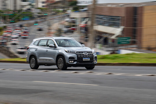 Silver Chery Tiggo 8 Pro SUV front view panning shot, Chinese 7-seater car driving in city