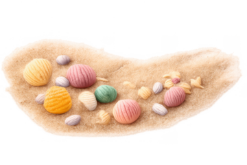 Colorful crochet seashells and ocean elements resting on soft sand creating a charming beach scene, transparent background