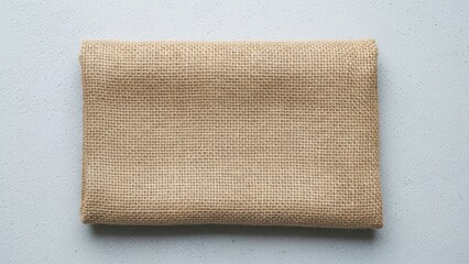Folded burlap fabric on a light gray surface