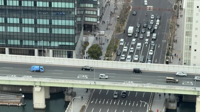 Aerial perspective of busy city intersection with highway bridge and street traffic