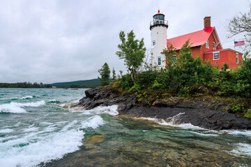 Waves crash at Eagle Harbor Lighthouse in the Upper Peninsula of Michigan on a brisk day