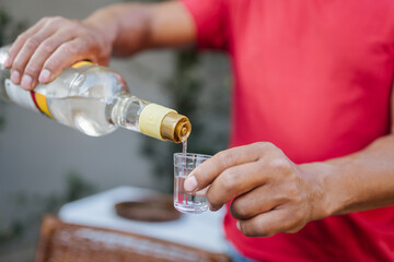 Man Pouring a Shot of Brazilian Cacha&ccedil;a or Clear Spirit into a Glass