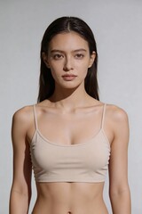 Fototapeta premium Front view portrait of a young woman wearing a beige top looking directly at the camera.
