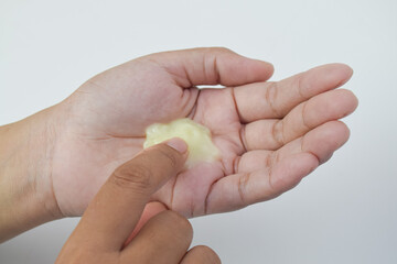 Yellow liquid cosmetic cream application on palm. Skincare treatment, moisturizing lotion texture on hand.