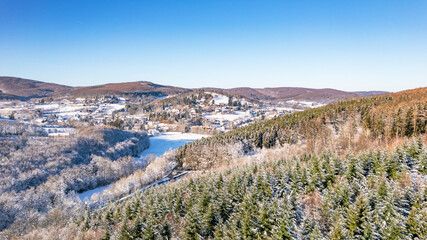 Winterpanorama mit schneebedeckten Hügeln, Wald und klarer Sicht