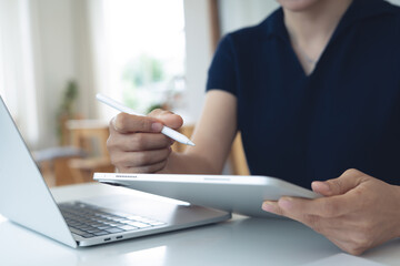 Casual business woman using digital tablet, working on laptop computer at coffee shop, remote work. Female student online studying, E-learning