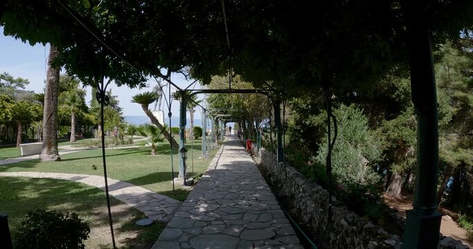 Pov walk in pavement walkway in the gardens of Achillion palace on Corfu island, Greece