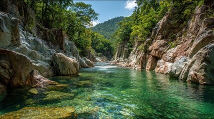 Crystalline river flowing through rocky canyon, lush green foliage under blue sky
