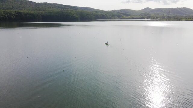 View from above. A rower trains on a kayak on the lake.