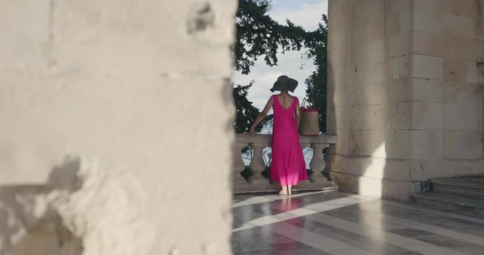 Red dressed woman sightseeing Corfu island in Greece, slow motion