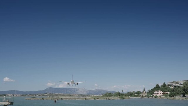 Aircraft landing at Corfu island airport during summer vacation, slow motion