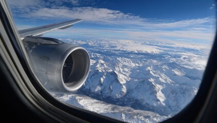 Aerial view of snowy mountains through airplane window