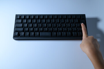 Close up of a finger pressing the enter key on a black keyboard