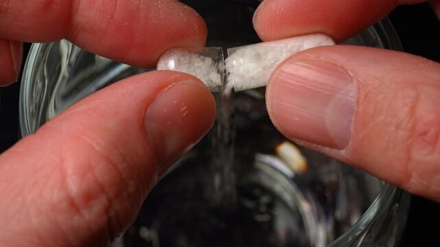 Spiking sedative in glass with adult drink. Drink spiking. Club cocktail in the disco party get drugged. Putting drugs in drink at the bar.