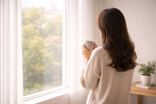 창가에서 커피를 들고 사색하는 사람의 뒷모습과 워크라이프 밸런스