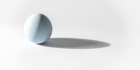 a single light blue easter egg isolated on a white surface.with shadow. minimalist background with copy space