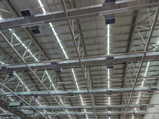 Industrial warehouse ceiling structure with lighting and ventilation system, featuring modern architecture and functional design.