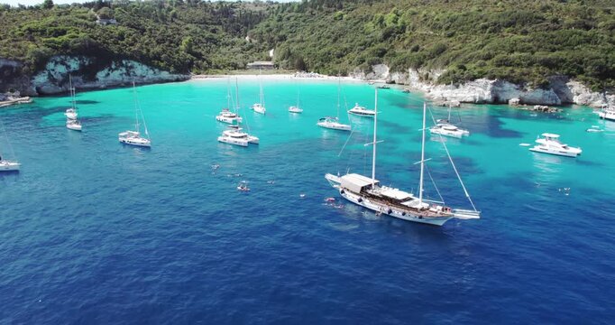 Aerial drone view of luxury yacht boats at the breathtaking Voutoumi beach, Antipaxos Greece