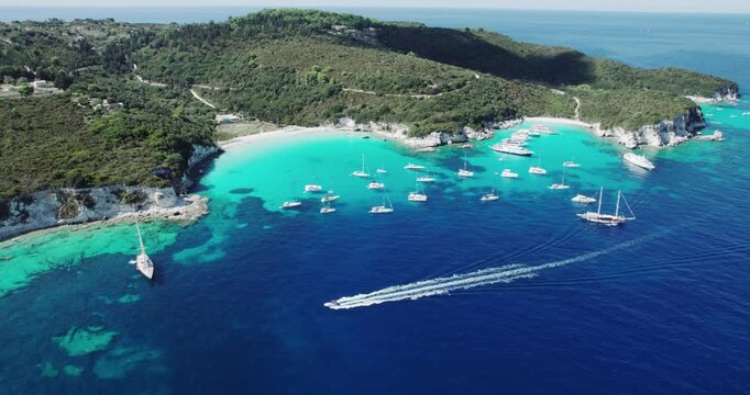 Tropical paradise turquoise tranquil sandy beach of Mesovrika with sail boats docked in island of Antipaxos, Ionian, Greece