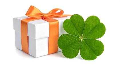 White gift box with an orange bow next to a green four-leaf clover