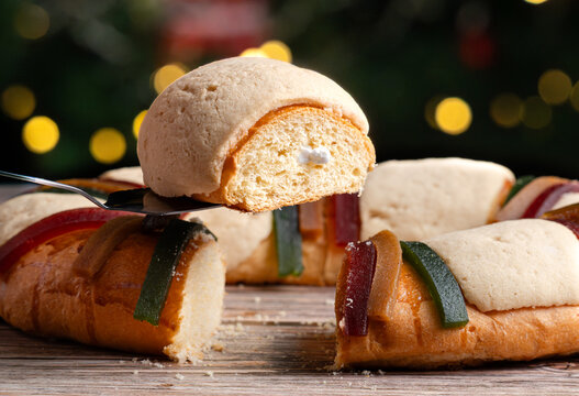 Three Kings Day in Mexico, A slice of rosca de reyes with the figure of the baby Jesus, Christmas background
