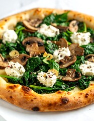 Close-up of a pizza with mushrooms, spinach, and creamy cheese