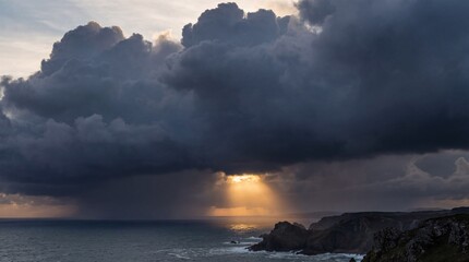 Dramatic storm clouds gather over the ocean with sunlight breaking through below