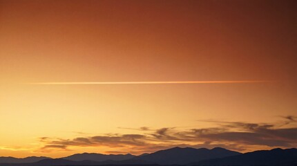 Fototapeta premium A vibrant sunset over distant mountains creates a peaceful and warm horizon
