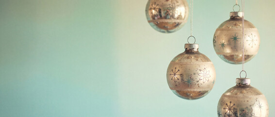 Delicate silver Christmas ornaments with snowflakes hang against aqua