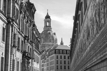 Fine art black and white street view in Dresden, Germany, featuring Women&rsquo;s Church dome and the famous Procession of Princes mural. European architecture, cultural heritage and travel destination