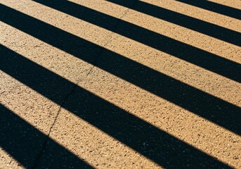Minimalist composition of sharp diagonal shadows crossing textured pavement. Dark lines intersect bright, sunny surfaces, emphasizing geometry and light play, modern, strong, graphic