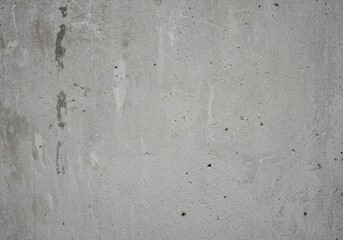 A weathered, rough surface of gray concrete wall displaying gritty details and natural imperfections. Useful as a backdrop or overlay, surface, natural, gray