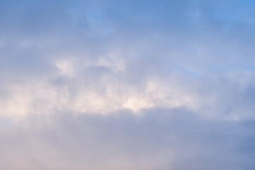Fototapeta premium Gentle pastel clouds drift across a serene blue sky, creating a peaceful and airy atmosphere with subtle gradients and diffused light.