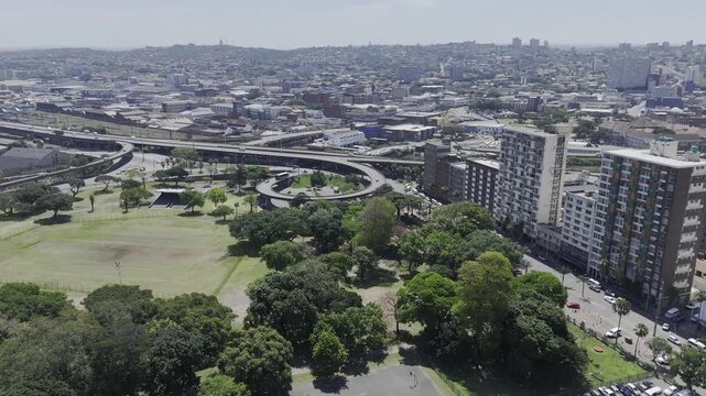 Drone flies west high over Albert Park on sunny day in Berea, Durban, South Africa