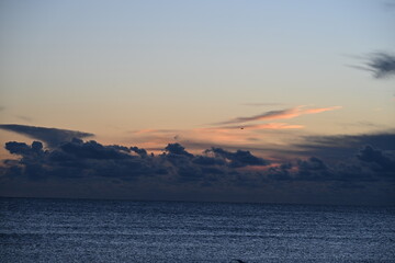 Sunrise over the sea with an orange sky and gentle waves
