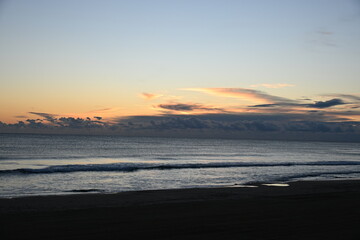 Sunrise over the sea with an orange sky and gentle waves
