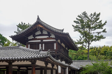 Obraz premium Historic low-angle view of wooden temple building surrounded by lush greenery