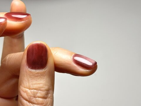 マグネットネイルをセルフで楽しむ女性が横から塗りの最終確認をしている