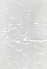 Abstract crumpled plastic texture with glowing light reflections creating a metallic and futuristic effect. Shiny surface and intricate folds form abstract background for modern design concepts.