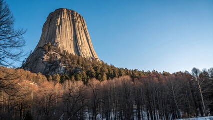 Majestic Devils Tower surrounded by autumn trees under clear blue sky