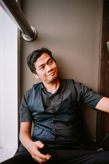 Young Asian man with a gentle smile looking sideways