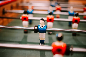 Foosball player in blue jersey on game table