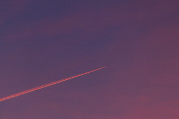 Jet plane flying in the blue sky. Wake leaving trace or steam jet