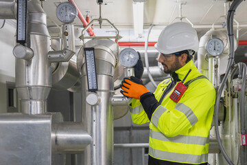 Industrial Cooling System Inspection Civil engineer manager and foreman worker conducting a thorough inspection of the building's industrial air conditioning and water cooling tower
