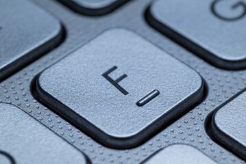 Close-up macro view of the "F" keys on a gray laptop keyboard with detailed texture and selective focus.