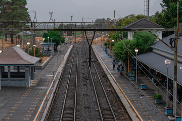 Fototapeta premium Empty Paarl Station in South Africa's Western Cape on a rainy day, its sleek blue-and-white cars contrasting with the historic platforms and commuters.