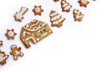 Small Gingerbread cookies in shape of gingerbread men, house, tree, and stars  on white background with copy space. Christmas concept