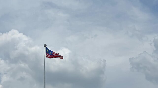 National flag of Malaysia waving against a cloudy sky