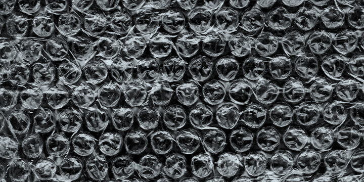 Wrinkled plastic wrap texture on a black background. Cellophane package wallpaper